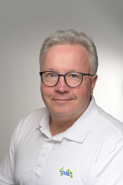 Mann mit Brille und weißem cds-Polohemd.