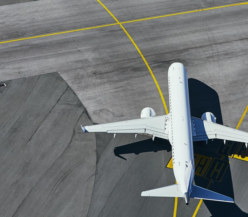 Flugzeug von oben auf Rollfeld mit gelber Linienführung.
